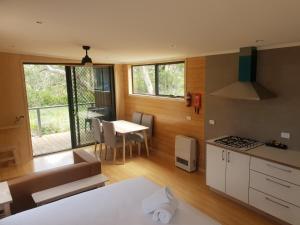 a room with a kitchen and a table with a stove at Bimbi Park - Camping Under Koalas in Cape Otway