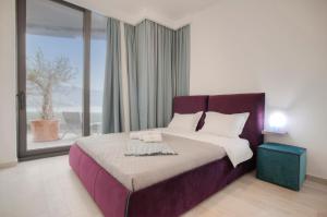 ein Schlafzimmer mit einem großen Bett und einem großen Fenster in der Unterkunft Royal Gardens Paradise in Budva