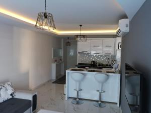 a kitchen with white cabinets and a kitchen island with stools at Elite Life Residence 4 in Avsallar