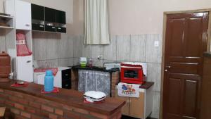 eine kleine Küche mit Theke und Mikrowelle in der Unterkunft Suíte ampla com cozinha Ibitipoca in Conceição da Ibitipoca