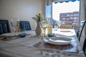 a table with a plate and wine glasses on it at Apartamento cómodo a 10 min del centro in Alicante