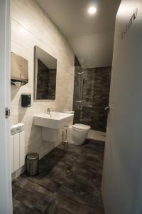 uma casa de banho com um lavatório, uma banheira e um WC. em Albergue Casa Manola em Abeleiras