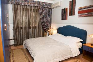 a bedroom with a blue bed and a window at DB Apartment in Tirana