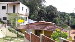 Una casa con una flecha amarilla encima. en Suíte ampla com cozinha Ibitipoca, en Conceição da Ibitipoca
