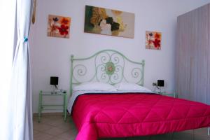 拉斯佩齊亞的住宿－Casa Brin，一间卧室配有粉红色的床和两张桌子