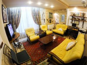 a living room with a yellow couch and yellow chairs at DB Apartment in Tirana
