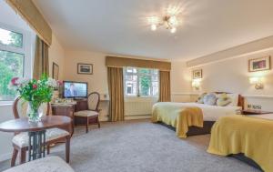 Habitación de hotel con 2 camas y mesa en Bushtown Hotel & Spa en Coleraine