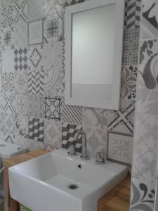 a bathroom with a white sink and a mirror at Mirador del Bosque Aparts in El Chalten +52 photos