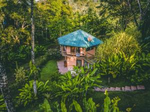 an aerial view of a small house with a blue roof at Manoas in Uvita