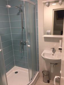 een badkamer met een douche en een wastafel bij MOKKA PANZIÓ in Szarvas
