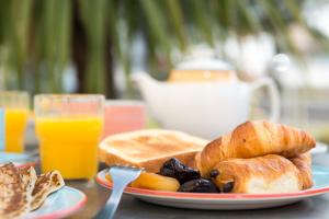 - une assiette de nourriture avec du pain, des croissants et du jus d'orange dans l'établissement The Originals City, Hôtel La Belle Étape, Brignoles (Inter-Hotel), à Brignoles