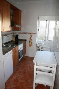 una pequeña cocina con mesa blanca y fregadero en Don Pelayo, en Barbate