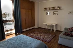 sypialnia z łóżkiem, stołem i oknem w obiekcie Casa Sottoripa w Genui