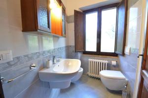 a bathroom with a sink and a toilet and a window at All'Ombra di San Damiano in Assisi