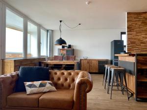a living room with a couch and a kitchen at COAST HOUSE Havenquartier in Bremerhaven
