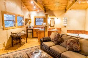 a living room with a couch and a kitchen at Riverside Cottage #26 in Ruidoso