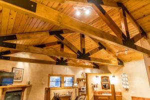 a room with a wooden ceiling with wooden beams at Riverside Cottage #26 in Ruidoso +17 photos
