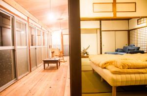 um quarto com uma cama e uma sala de estar em Engawa em Tonosho