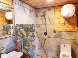 a bathroom with a toilet and a shower at Avaas - Bed & Breakfast in Nainital +11 photos