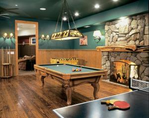 a room with a pool table and a stone fireplace at Circle Bar B Guest Ranch in Santa Barbara