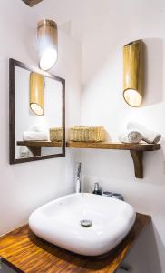 uma casa de banho com um lavatório branco e um espelho. em Fisheye The Rooms - Family room em El Nido