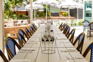 einen langen Tisch in einem Restaurant mit Stühlen in der Unterkunft The Waterloo Bay Hotel in Brisbane