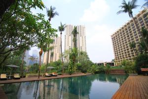una piscina en el centro de una ciudad con edificios altos en The Sultan Hotel & Residence Jakarta en Yakarta