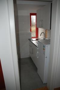 eine Küche mit weißen Schränken, einem Waschbecken und einem Fenster in der Unterkunft Kegel Tanz Palast Winterberg in Winterberg