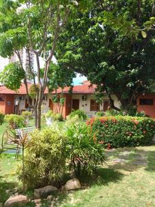 um jardim com uma casa e alguns arbustos e árvores em Hotel Jardim em Fortaleza