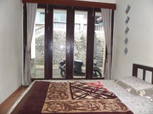 a bedroom with a bed and a large window at Villa Anna in Bromo