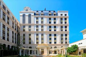 a large white building with a clock tower at Golden Tulip - Aesthetics in Zhunan