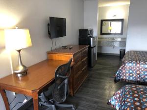 a hotel room with a desk and a bed and a room with a deskablish at Magnolia Inn Laurens in Laurens