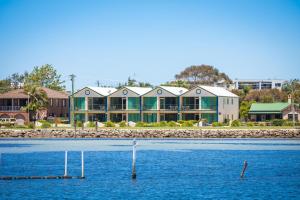 a large building on the shore of a body of water at Cetacea Luxury Apartments in Merimbula