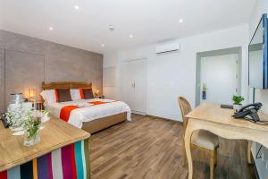 a bedroom with a bed and a desk and a table at Viewpoint Boutique Living in Xlendi
