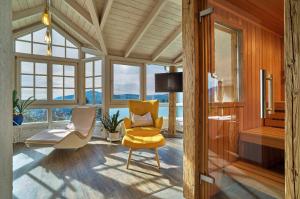 a living room with yellow chairs and windows at Haus Talblick in Bodenmais