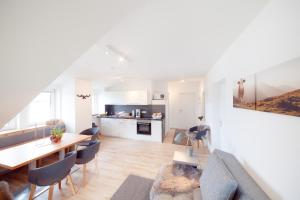 a living room with a dining room table and a kitchen at Apartment Bergkristall in Sonnenalpe Nassfeld