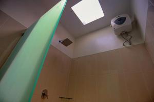 Un baño con ducha con pared verde. en Rahma Guesthouse, en Canggu 13 fotos más