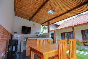 cocina con mesa de madera y sillas en Rahma Guesthouse, en Canggu