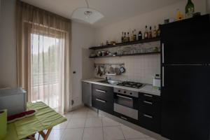 Il comprend une cuisine équipée d'un réfrigérateur noir et d'une cuisinière. dans l'établissement B&B Pierpy Appartamento Pescara Mare, à Pescara