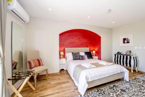 a bedroom with a large bed and a red wall at Viewpoint Boutique Living in Xlendi