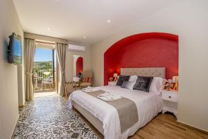 a bedroom with a large bed with a red wall at Viewpoint Boutique Living in Xlendi