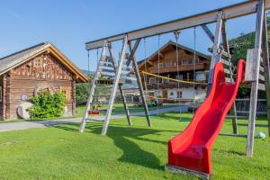 a playground with a red slide in front of a building at Appartement Arnoldgut in Altenmarkt im Pongau