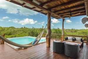 a deck with a hammock and a swimming pool at Casa HM Villa del Mar in Holbox Island