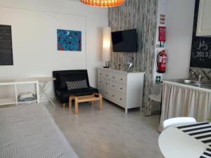 un soggiorno con sedia, cassettiera e TV di In Bed with Lisbon 8N ad Amadora
