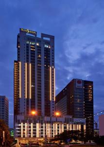 新山的住宿－Suasana Suites Hotel Johor Bahru，一座高大的建筑,上面有沙姆星标志