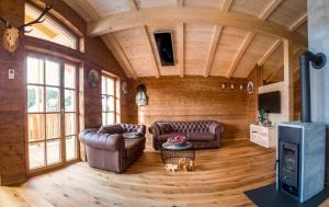 a living room with two leather couches and a tv at Jagdhütte in Lachtal