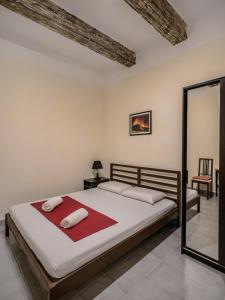 1 dormitorio con cama y espejo en Valletta Main Street Apartment en La Valeta