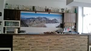 un bar con un grande schermo con foto di una montagna di Penzion Villa Gerlach a Nový Smokovec