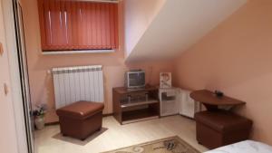 uma pequena sala de estar com uma televisão e uma mesa em Guest House Blisten em Sófia