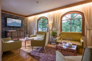 uma sala de estar com cadeiras e uma televisão e janelas em Ferienhotel Neuwirt em Hippach